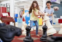 Two children playing giant chess at a science centre